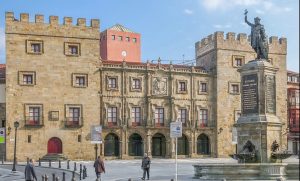 Estatua del rey Pelayo y Palacio de Revillagigedo en Gijón.