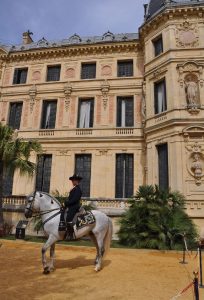 Jinete de la Real Escuela Andaluza de Arte Ecuestre ante la fachada del edificio de dicha escuela.